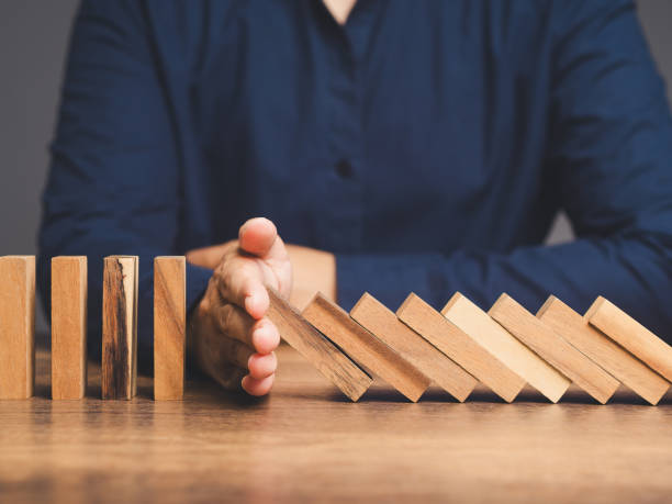 Business crisis management. Business professionals stop the crisis domino effect, safeguarding against business collapse. Prevent business failure through risk management